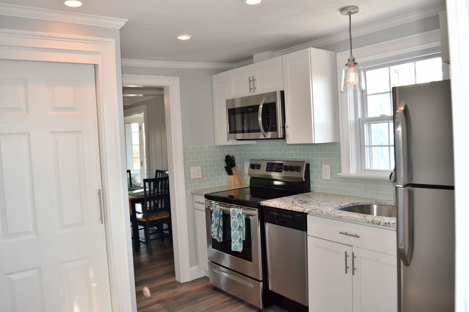 New granite counters, stainless dishwasher, stove, microwave, & tile backsplash