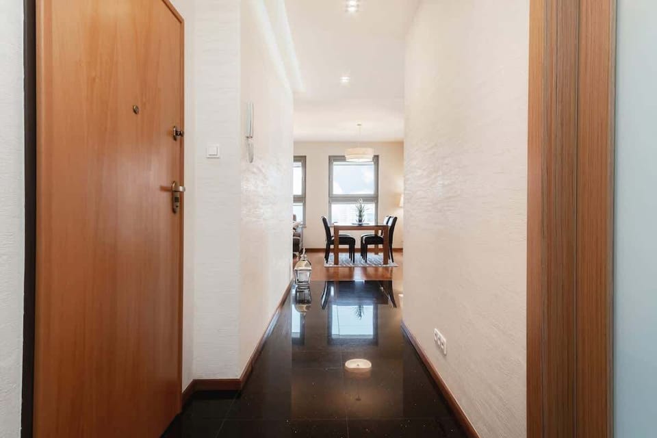 The spacious and bright hallway has doors to all rooms.