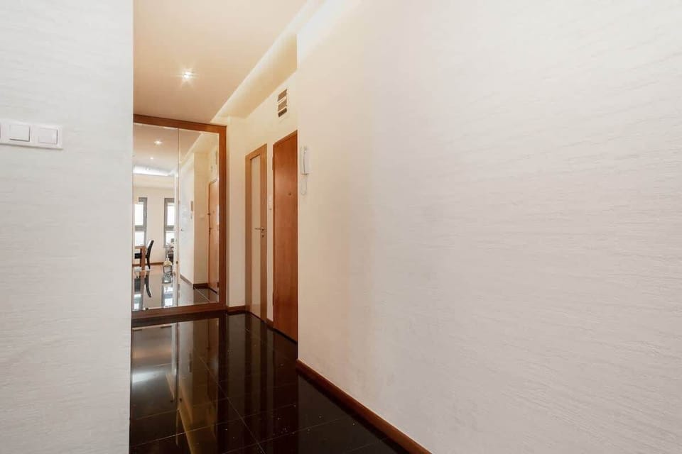 The spacious and bright hallway has doors to all rooms.