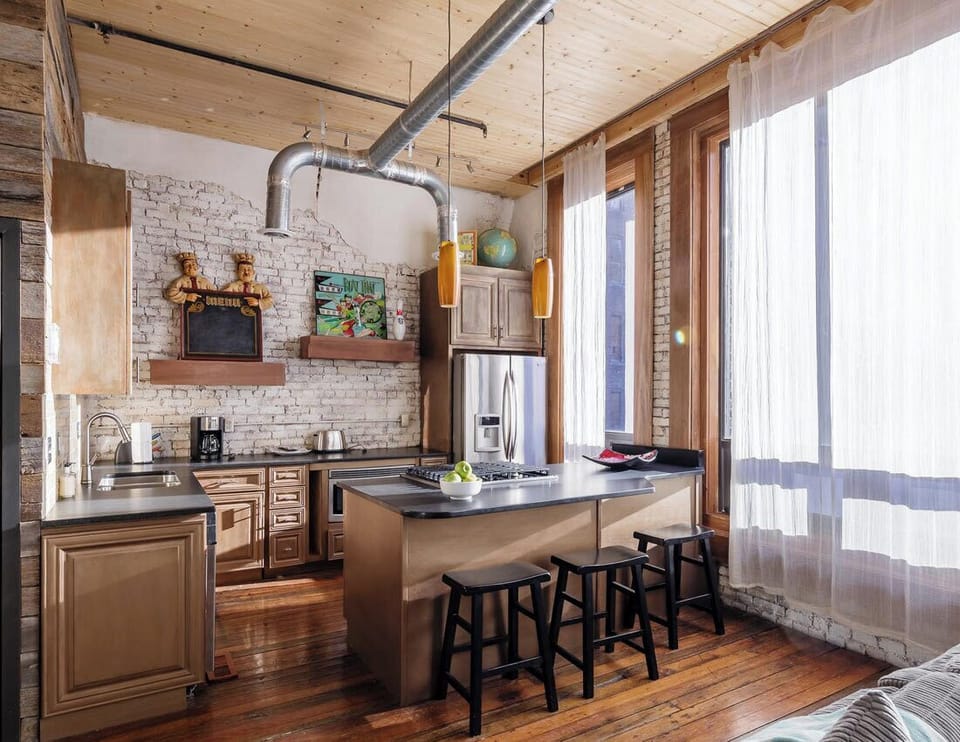 High-Ceiling Kitchen Featuring Brick Walls & Modern Appliances