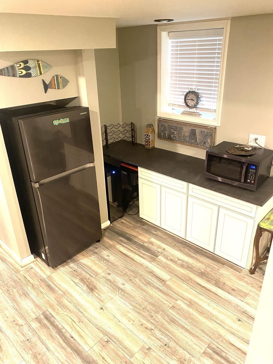 Lower level refrigerator and counter space with microwave.