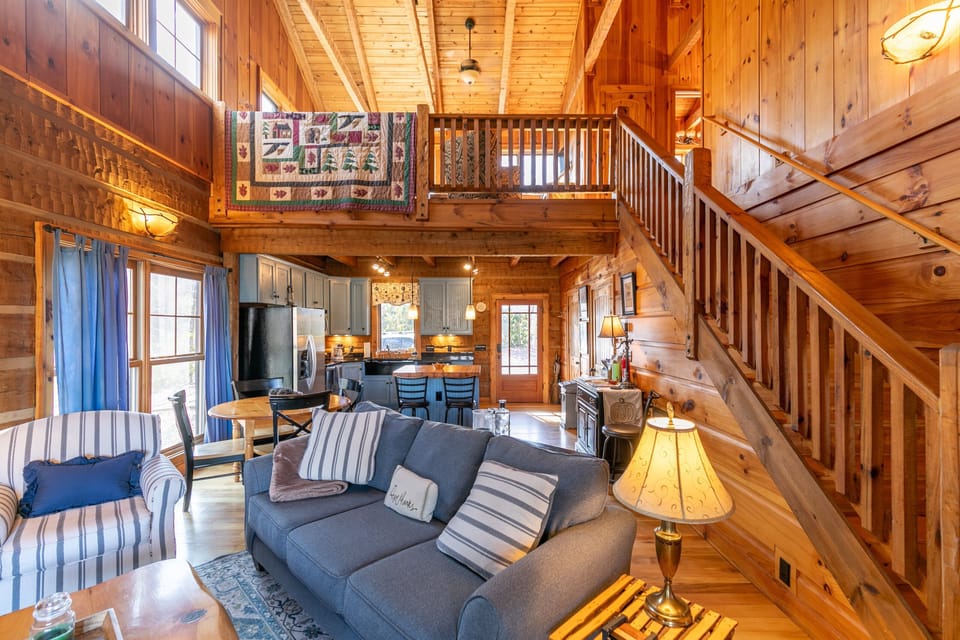 Soaring knotty pine ceilings and an open layout make the main living area at Walk In The Clouds feel like a true mountain retreat.