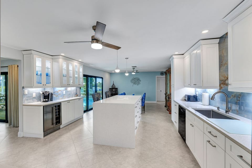 Bright culinary kitchen with under cabinet lighting and stainless steel sink.