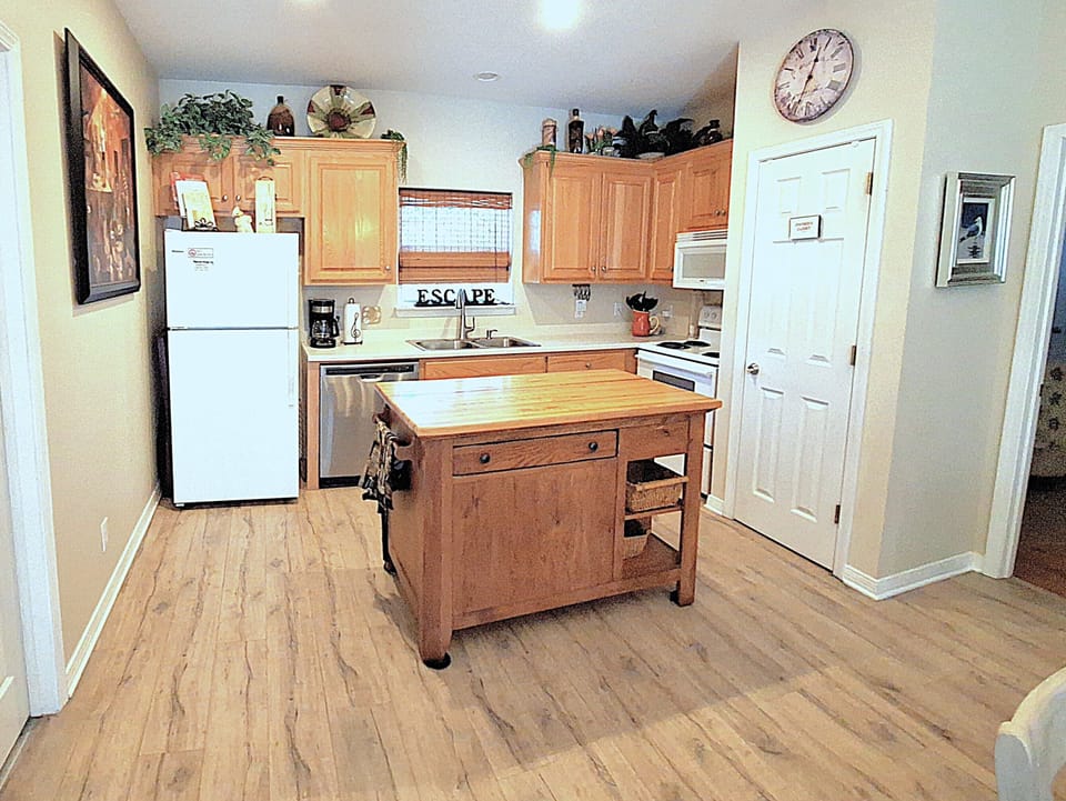Kitchen fully furnished with dishes, glassware, pots, pans, utensils, appliances