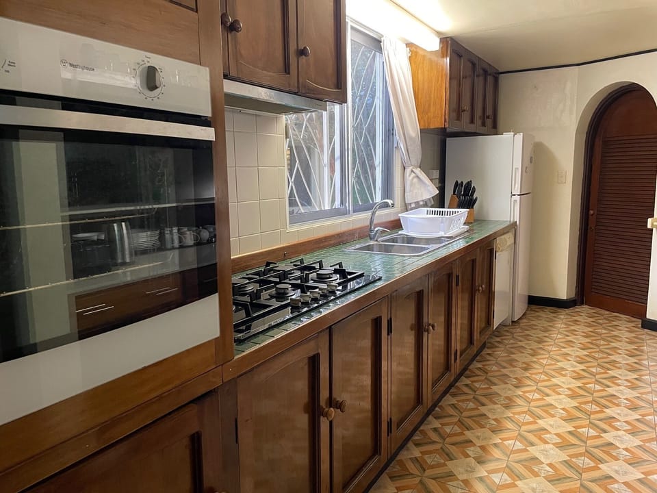 Oven, stove top, fridge, tile counters and newly tiled floor.