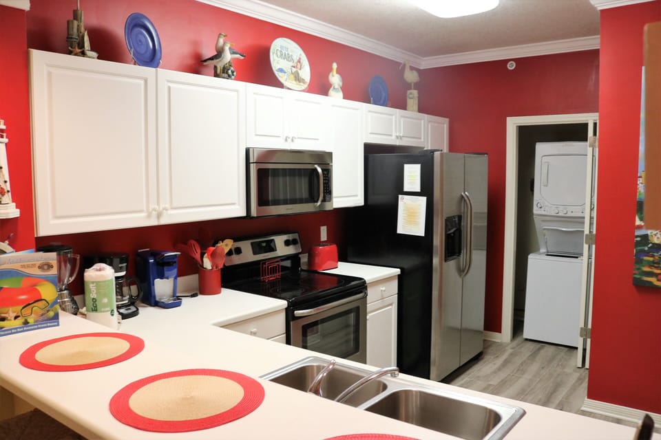 Large kitchen with side by side refrigerator, pantry, laundry, bar with 3 stools