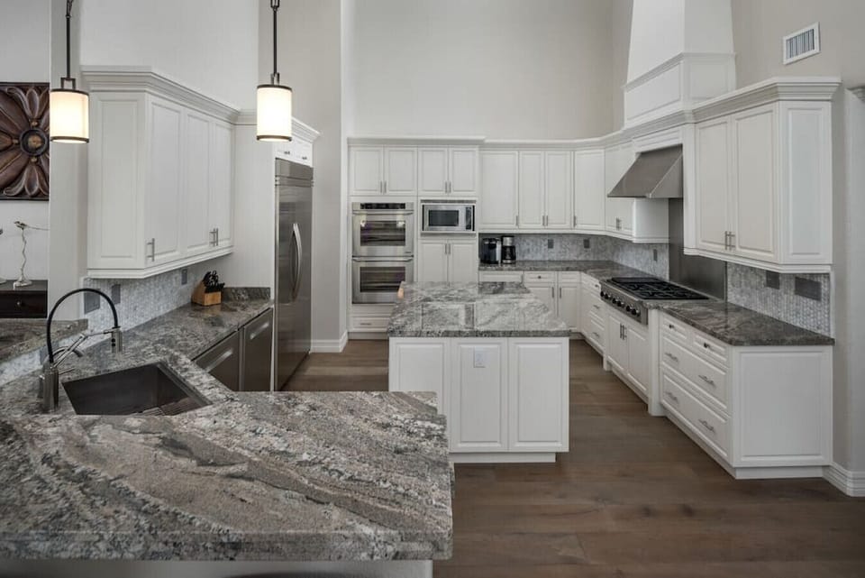 [Main Kitchen] Fully equipped for gourmet cooking with double ovens, gas range, huge side by side fridge, and two dishwashers