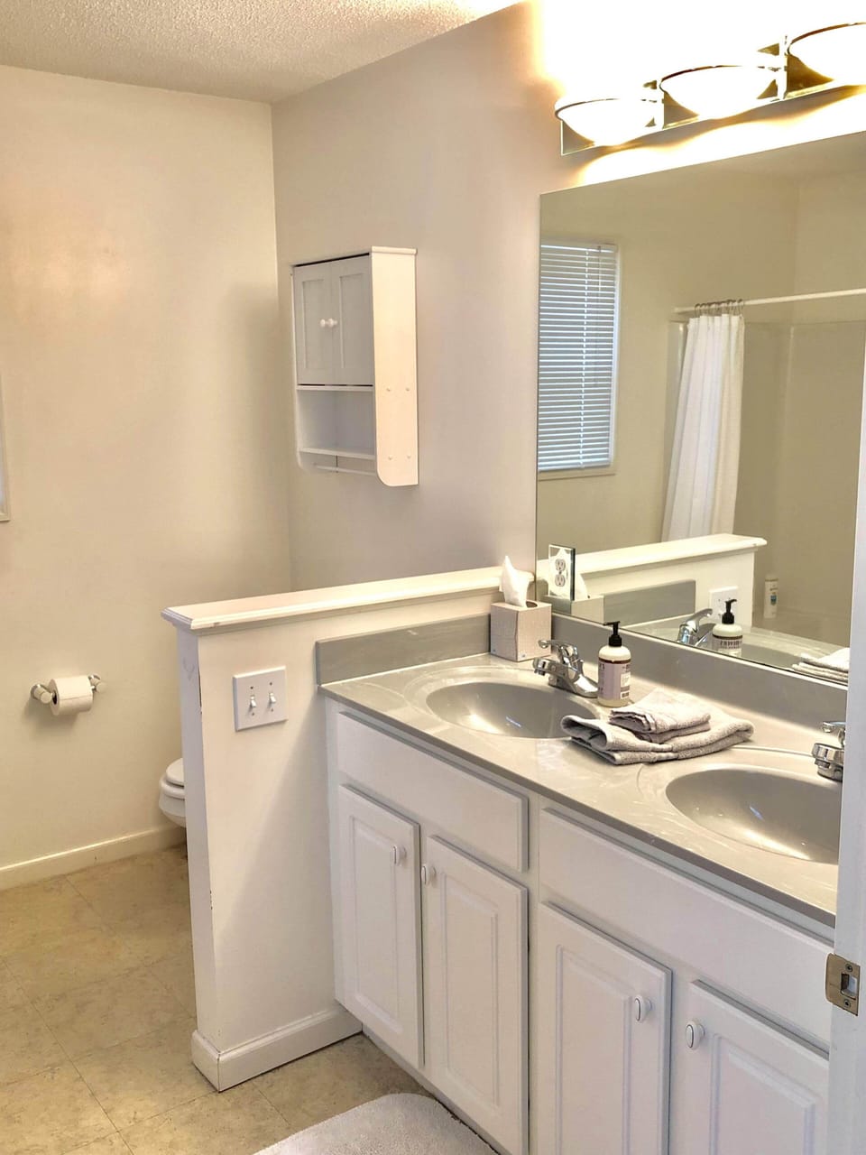 En suite full bathroom with double vanity, shower and separate bathtub in the bedroom with 2 queen beds