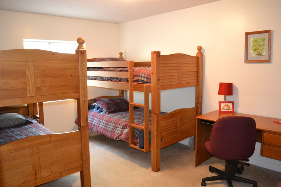 Downstairs bedroom with two bunk beds and a desk