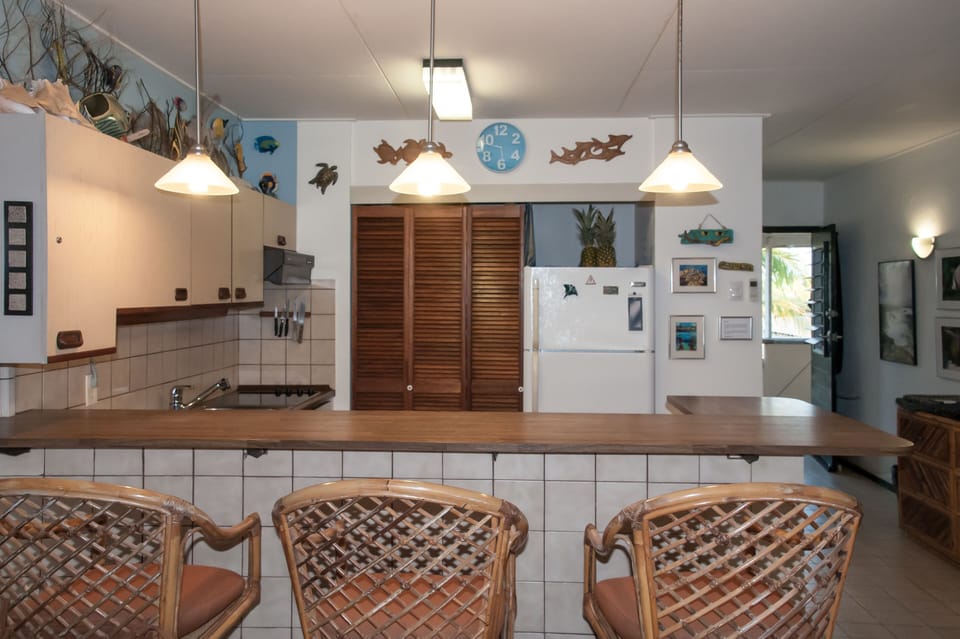 Bar with stools facing the pantry and refrigerator.