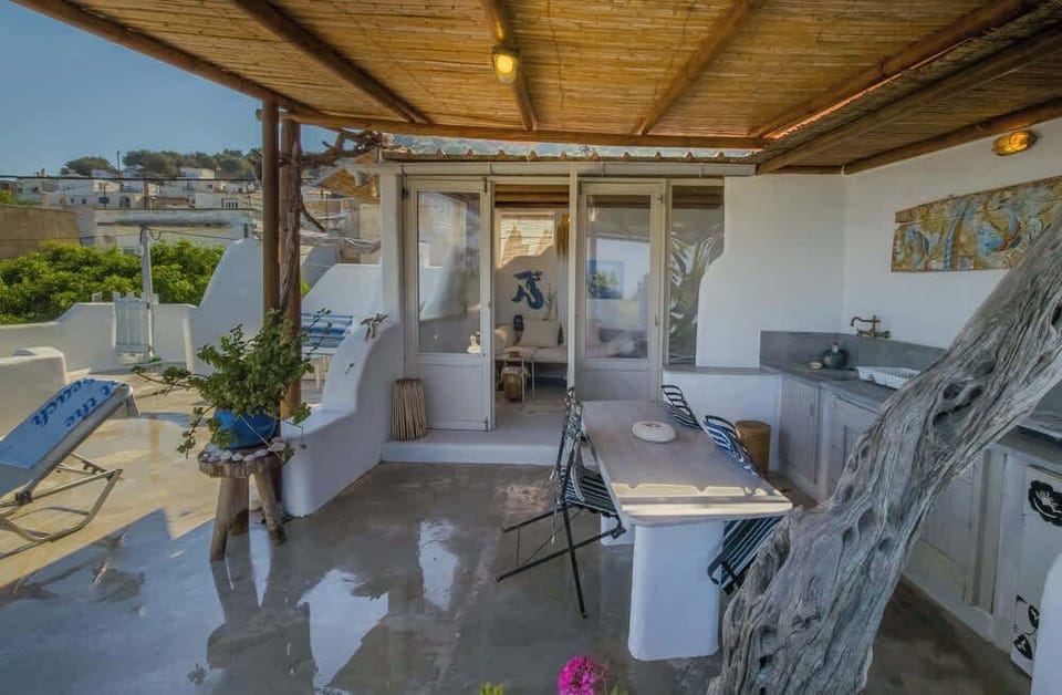 The rooftop area has a sink, a dining table, a covered lounge, shower and toilet