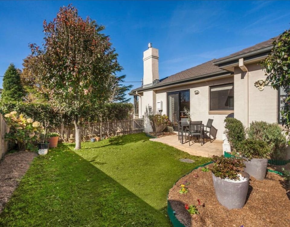 The rear of the property with outdoor setting and enclosed back yard with lawn

