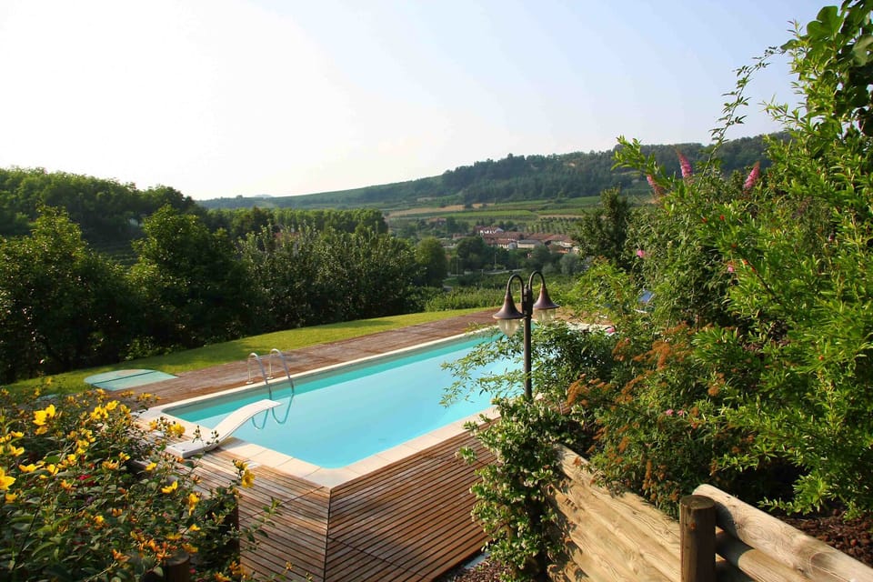 Private pool surrounded by greenery, flowers and teak wood area