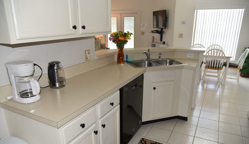 Kitchen area with kettle and coffee pot.