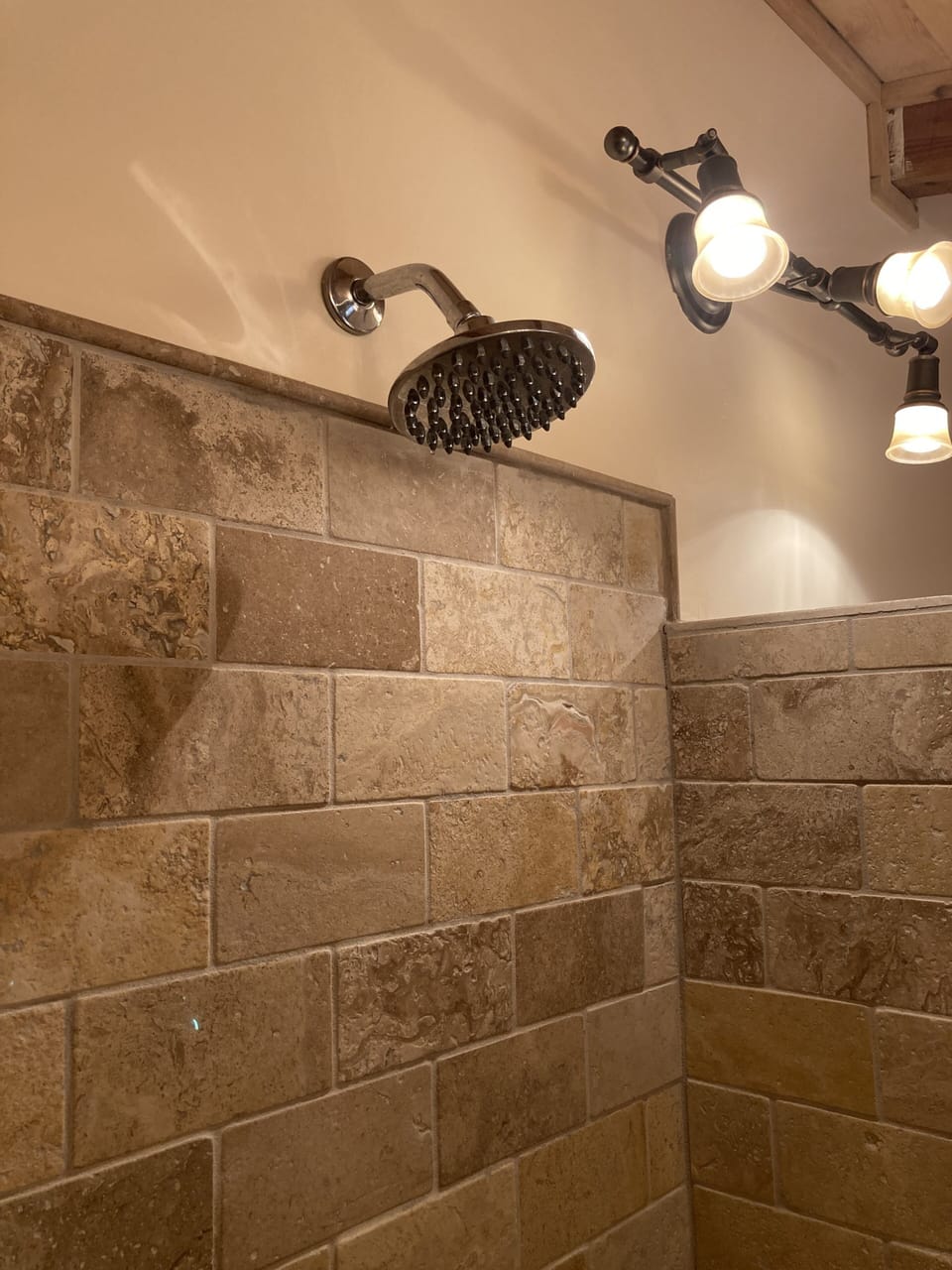 Rainhead shower head in large tiled shower.