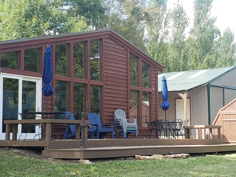 Back of cabin with great deck, picnic tables, hot tub, and gas grill.
