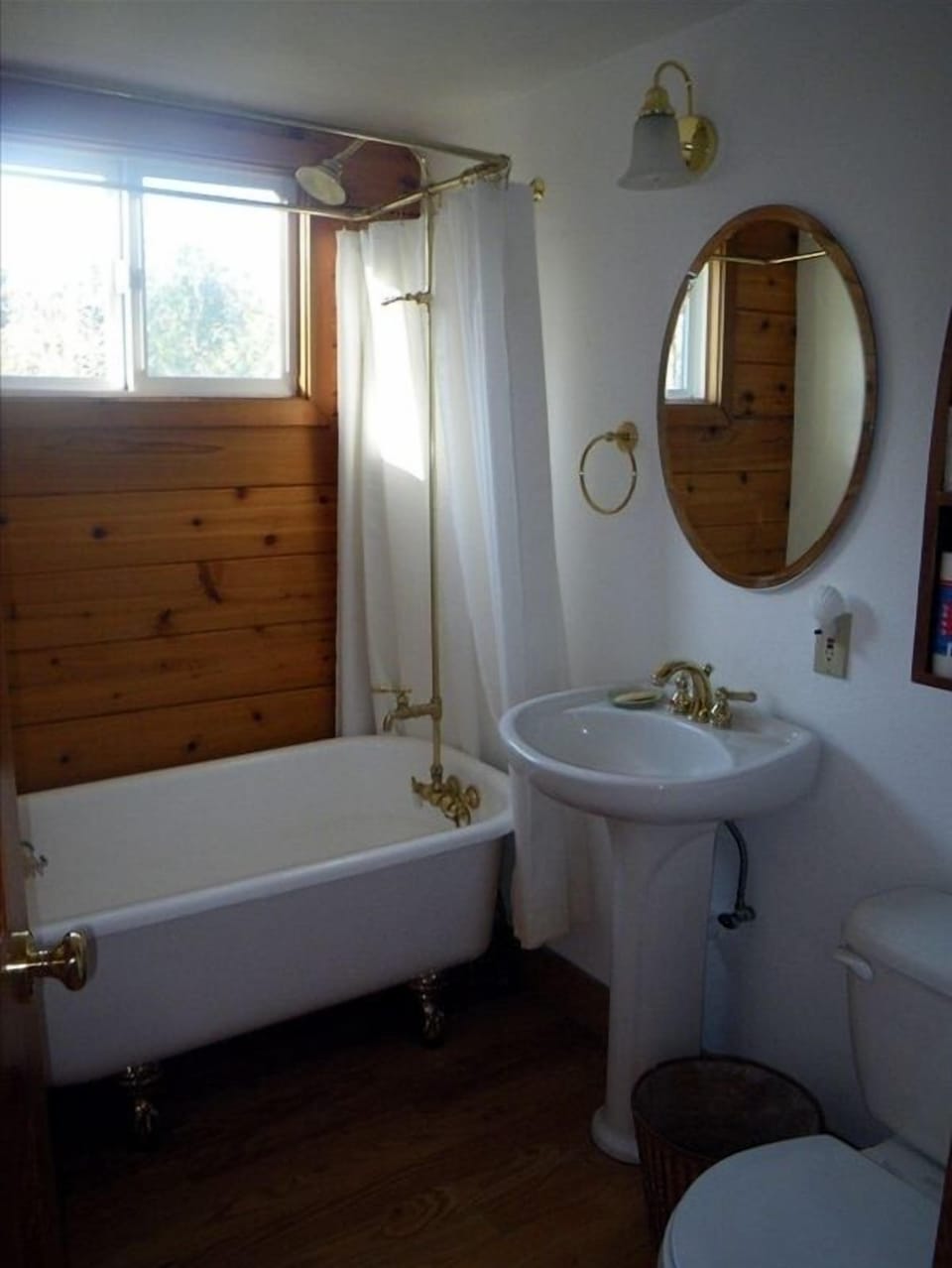 Downstairs bath with clawfoot tub and bright sunny lighting.