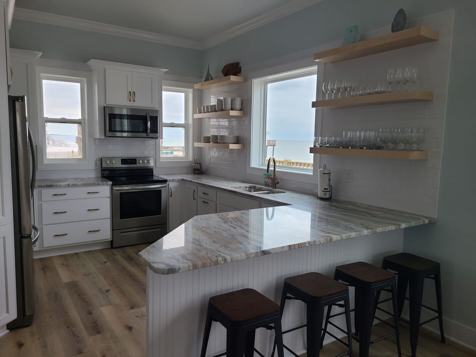 View of kitchen, granite counters.  Ice maker in fridge. Bar seating for 4.