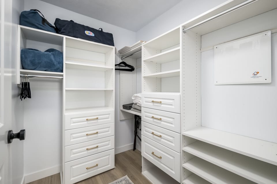 Master closet with plenty of drawers, hanging and shoe space