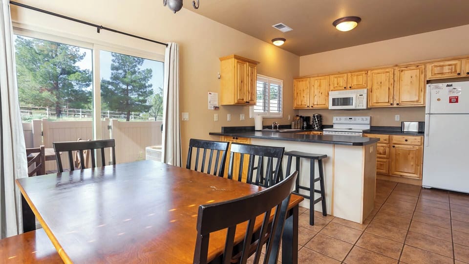 Cook and connect! The spacious kitchen at Staircase to Heaven boasts a dedicated dining area and a convenient counter bar for extra seating.