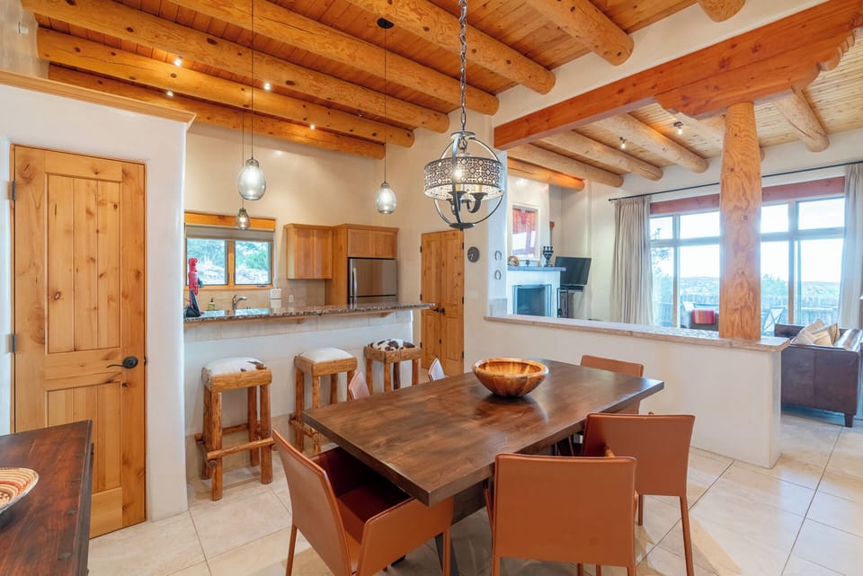 Gather around your private dining table beneath warm wooden beams, where natural light streams through panoramic windows and every meal becomes a moment to savor together.