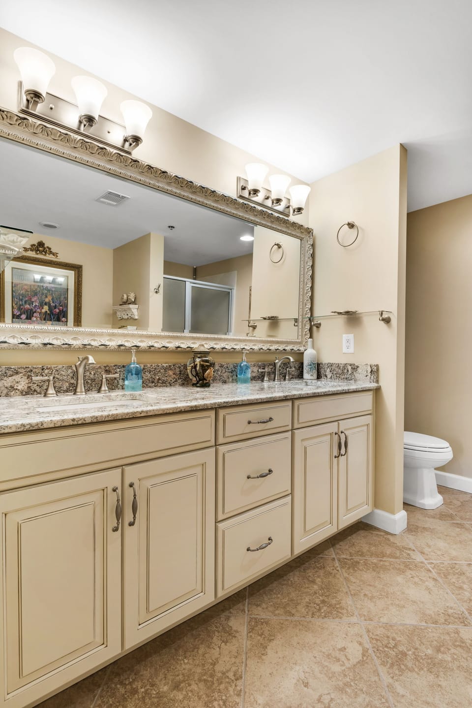 Master bath has full-length beveled mirror encased in frame & new light fixtures