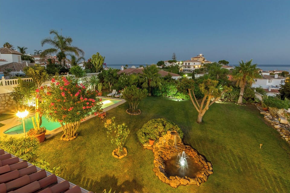 Night view from the upper terrace on garden, pool, fontain, sea and village 