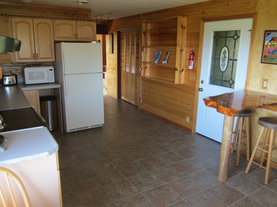 Entry door into kitchen and hallway leading to downstairs bath and living room