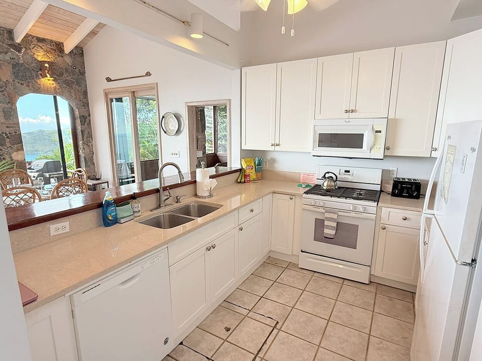 Your well equipped kitchen looks to the dining area and ocean views
