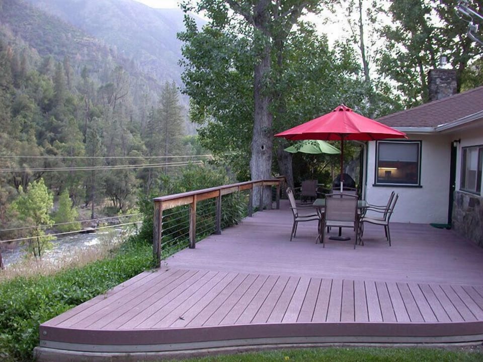 Large deck with two dining tables, BBQ, and big views of river and mountains