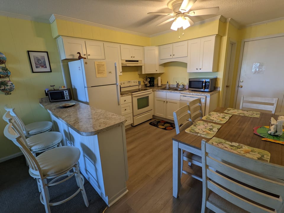 Wider view of kitchen and dining area