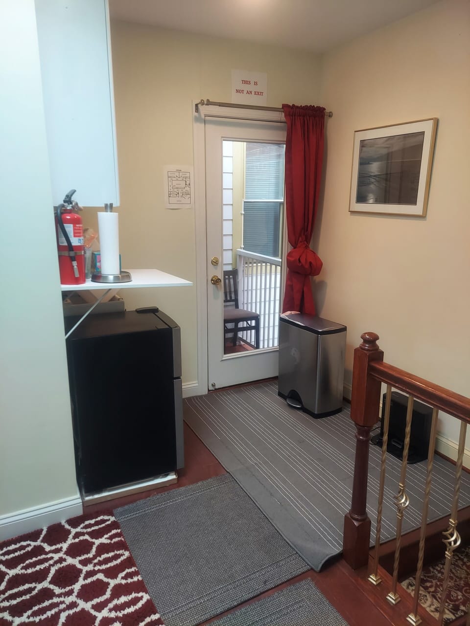 Wet bar on second floor at the top of stairs with door leading to small balcony.