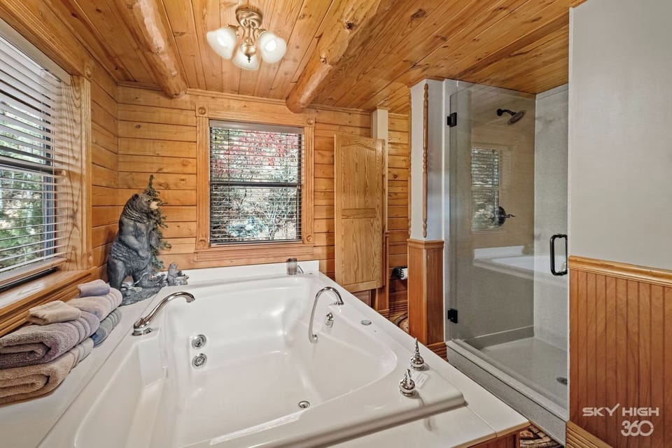 View of shower with bench and private bathroom. Shampoo, conditioner, and body wash are included.