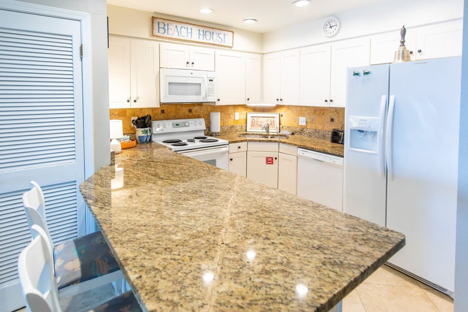 fully stocked kitchen with 2 counter chairs