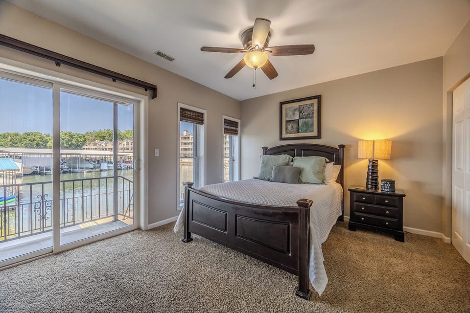 Cozy bedroom with balcony access and serene water views for relaxation.