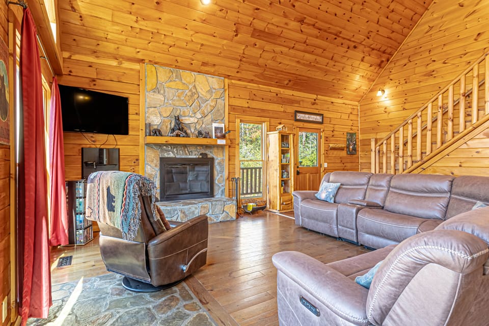 Living room, sectional and chair, TV, and wood burning fireplace