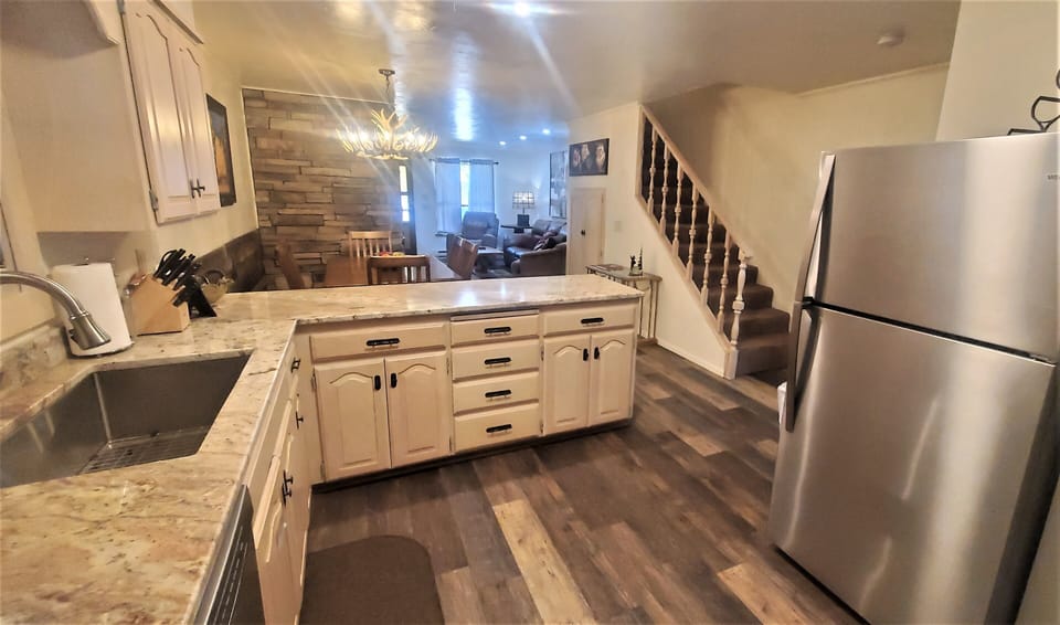 Step into a welcoming open-plan space where your fully-equipped kitchen flows into a cozy dining area and inviting living room. Modern appliances, rustic wood accents, and warm lighting create your perfect home base.