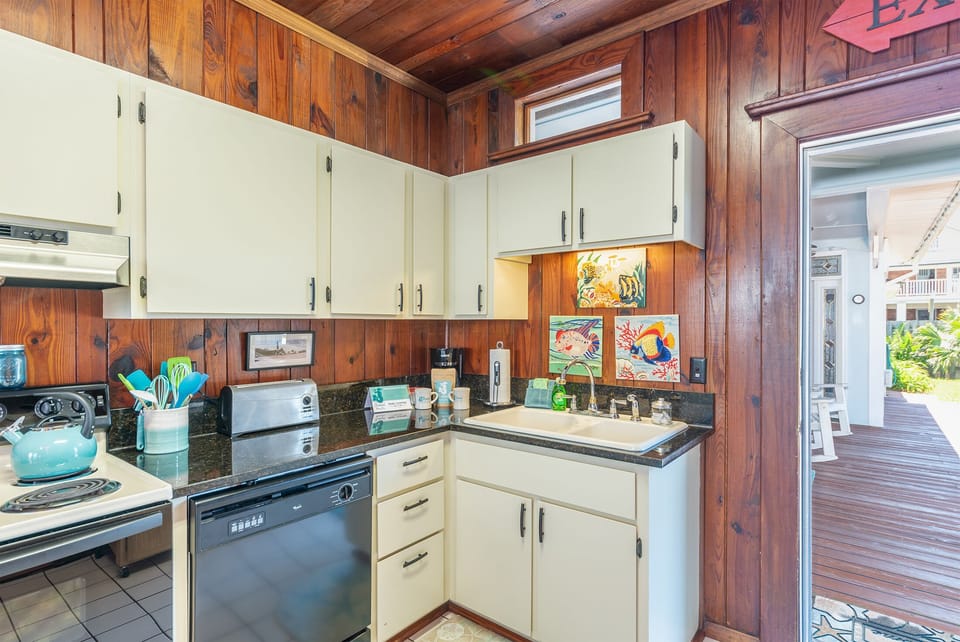 Wonderful vintage kitchen with modern accessories. We love the heart of pine walls and ceiling. You can open the kitchen door onto the front porch and eat outside in one of the many places to hang out!