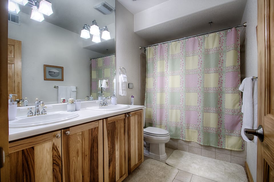 Full downstairs bath w/ jetted tub/tiled shower double sinks & hickory cabinets.