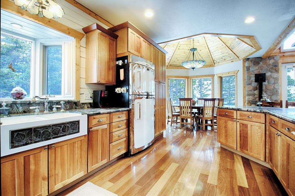 Huge fridge, apron-front sink, well-stocked cherry cabinets open to dining room.