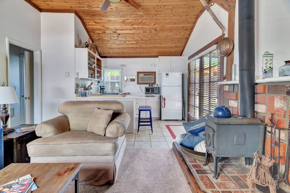 View of living room to kitchen and wood burning stove.