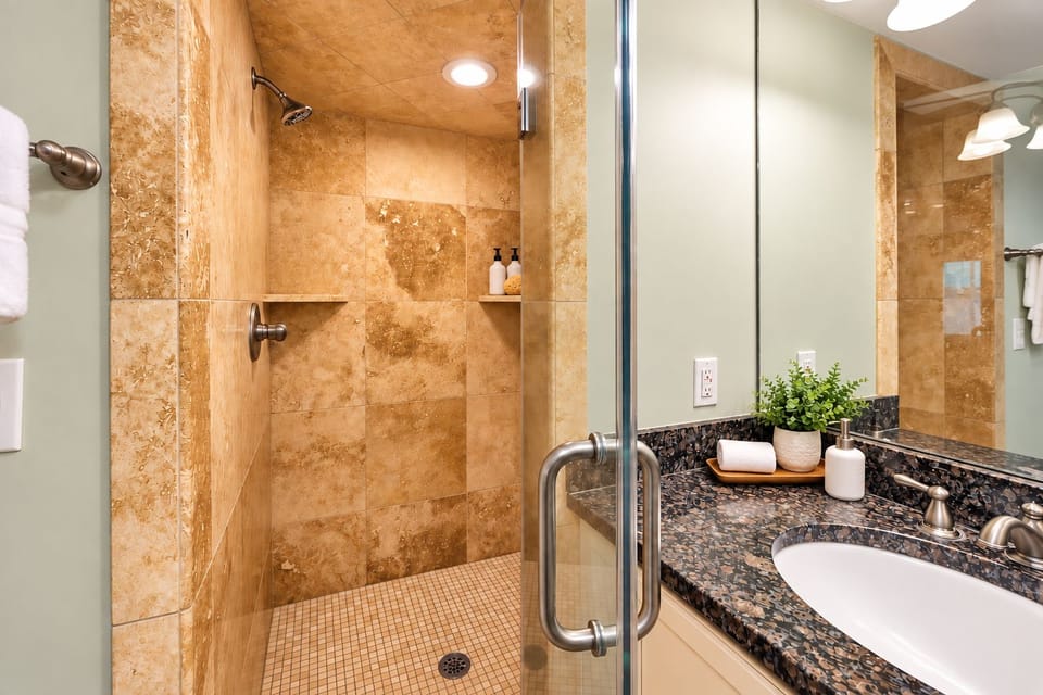 Travertine walk-in shower adds a refined touch to the primary bathroom