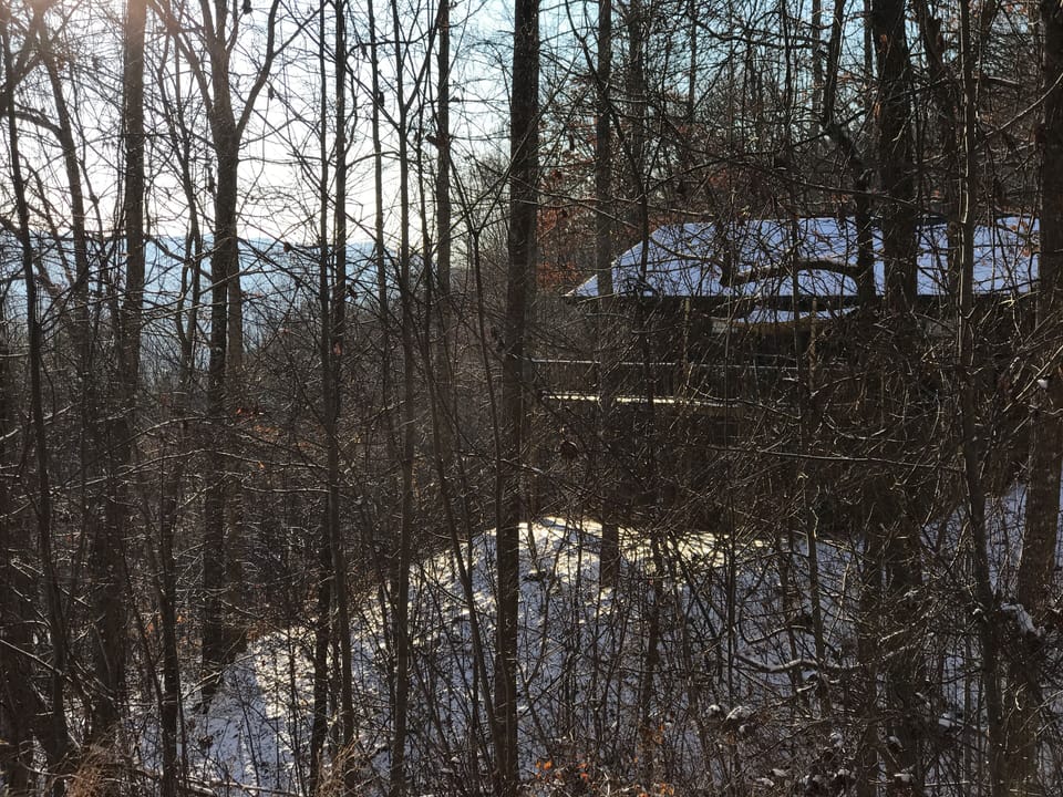 Winter view of the cabin through the snow. 