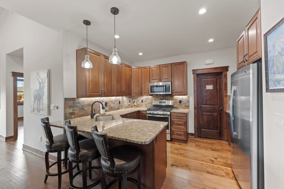 Your fully-equipped kitchen features rich wood cabinetry, granite counters, and a breakfast bar where you can sip morning coffee.