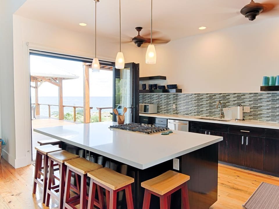 🌿 A gourmet space featuring a large social island, premium stainless steel appliances, and quality cookware. The open design keeps you connected to the Great Room and ocean views while you prep island-fresh meals. 🥂