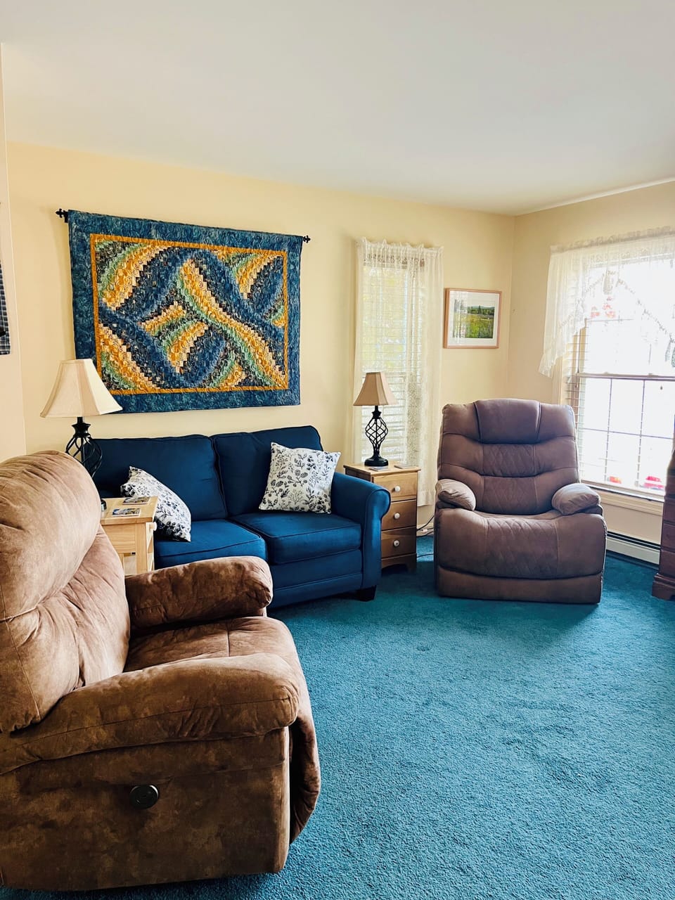 Living room with 2 electric recliners and also has an air conditioner.