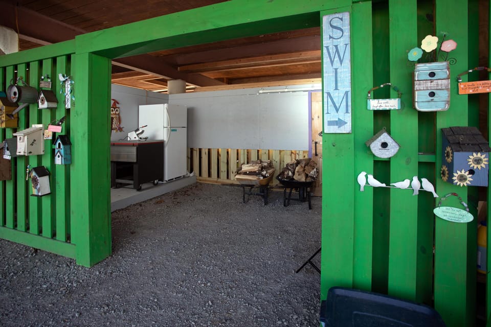 Ground level guest area with second fridge, games, and firewood.