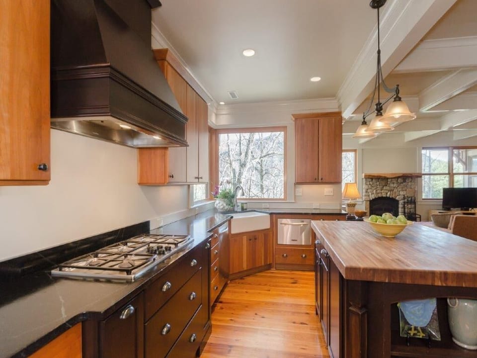 The kitchen has two refrigerators, dishwashers and ovens and plenty of dishes.