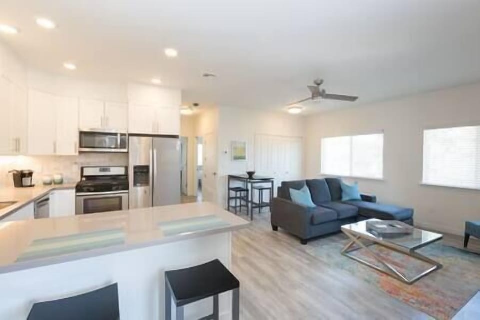 Enter a vibrant living space with fully equipped kitchen, seamlessly connected to bedrooms and bath