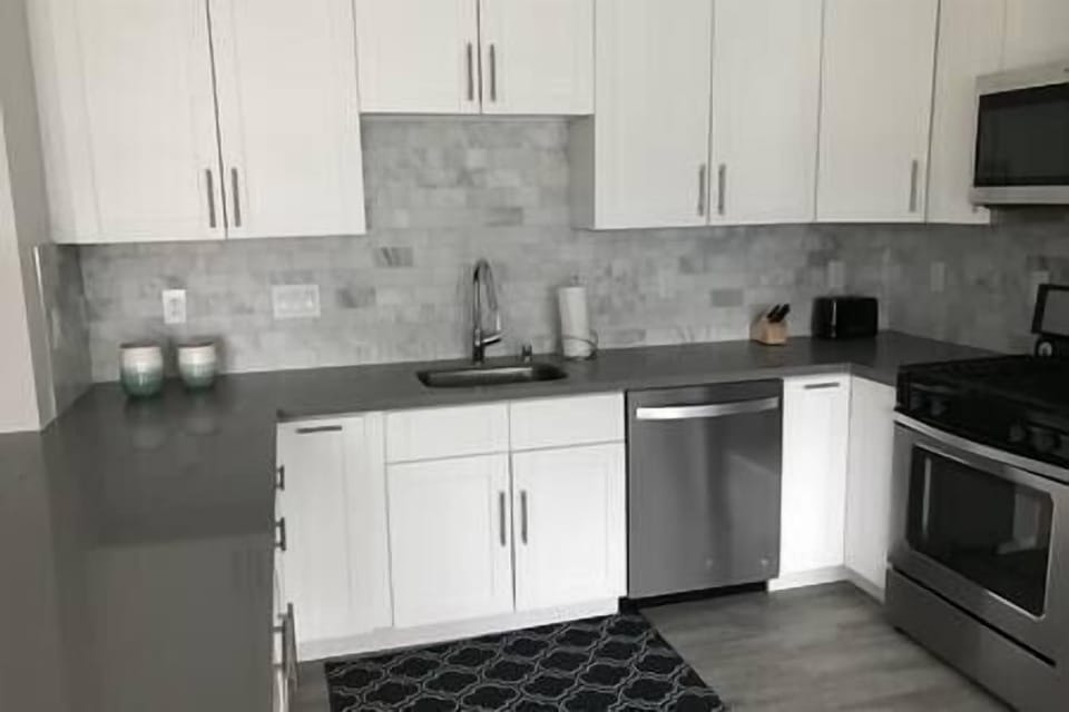 Fully-stocked kitchen with gas stove, oven, microwave, dishwasher, and Keurig, perfect for cooking.